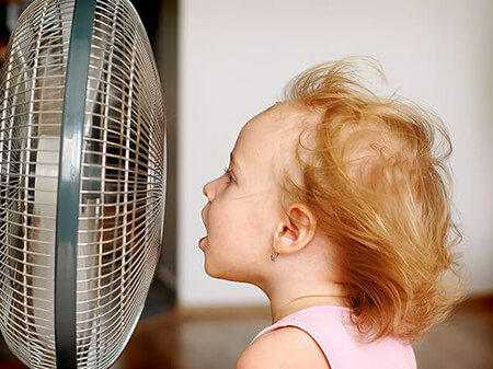 Girl sitting in front of fan 